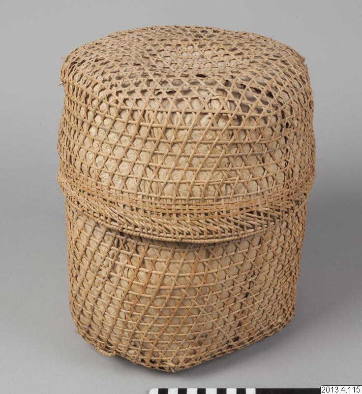 A complete pale woven basket with open latticework, a denser horizontal band and an inventory label beside the scale at the bottom.