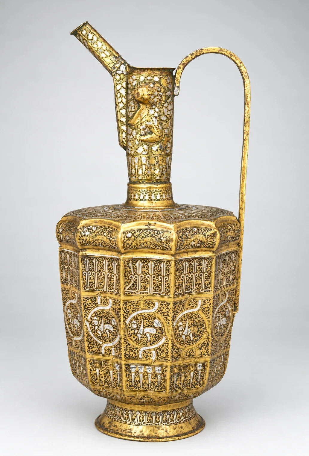 Inlaid twelve-sided ewer with tall spout and handle.
