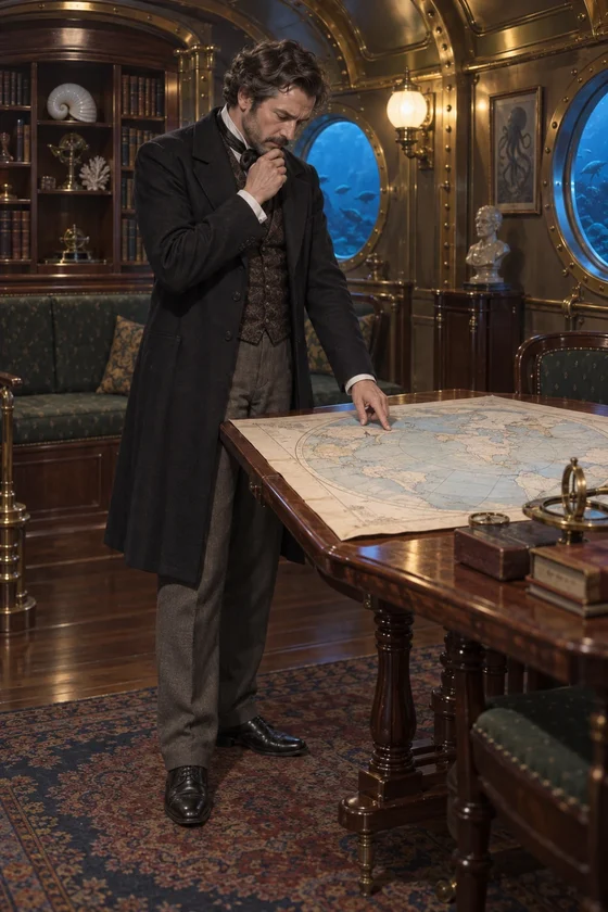 Imagined Aronnax touches a spread planisphere with one finger in the Nautilus saloon.