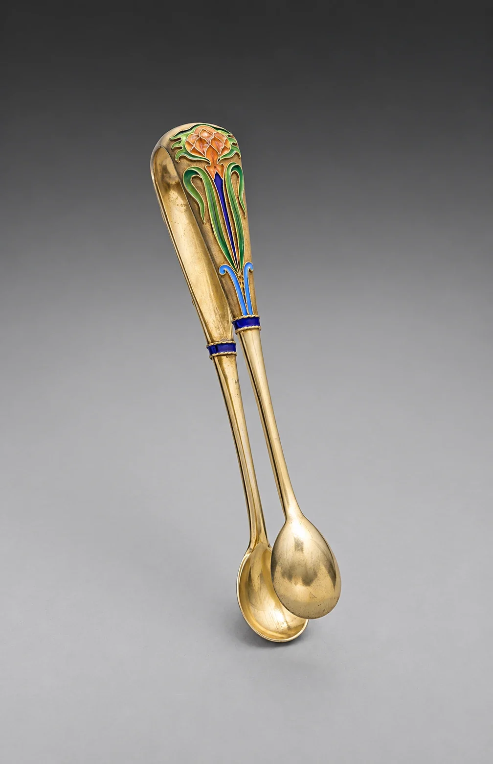Silver-gilt sugar tongs with floral enamel.