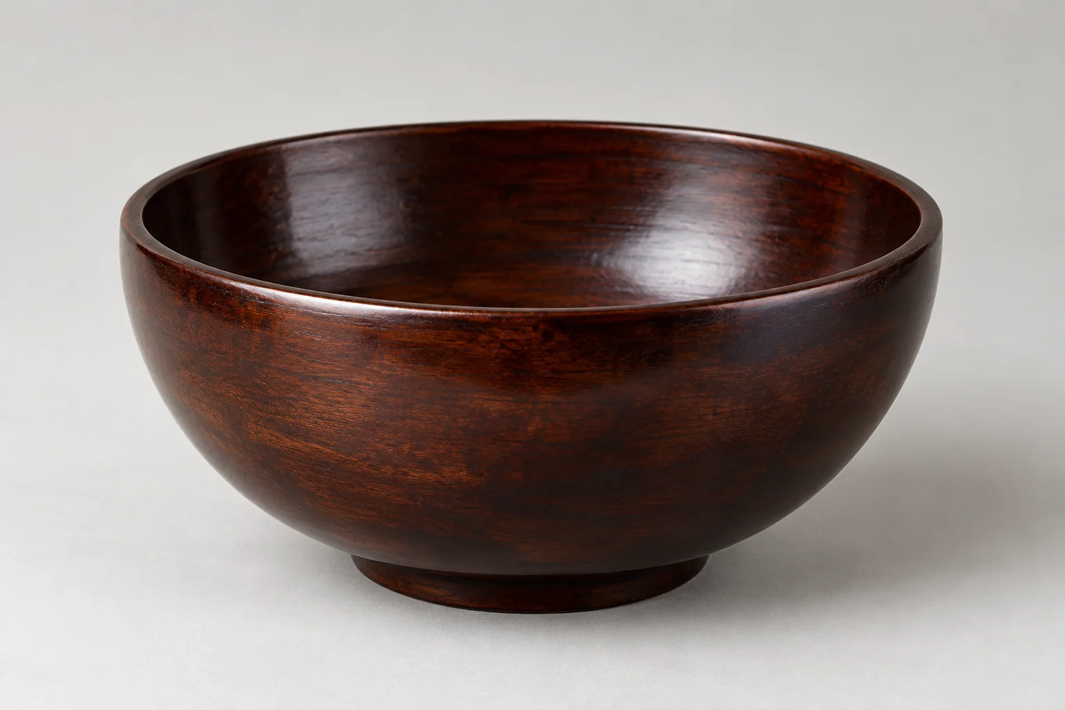 Plain wooden bowl with a dark polished coating.