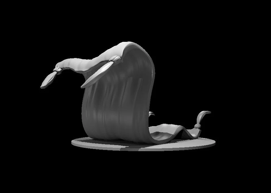 Grey rug miniature curled upright with raised tasselled corners, standing on an oval base against black.