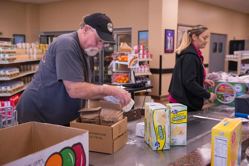 Joe Harris gathers groceries while Kyanna Wishon manages checkout at Chickasaw Nation Purcell Nutrition Services, USDA photograph