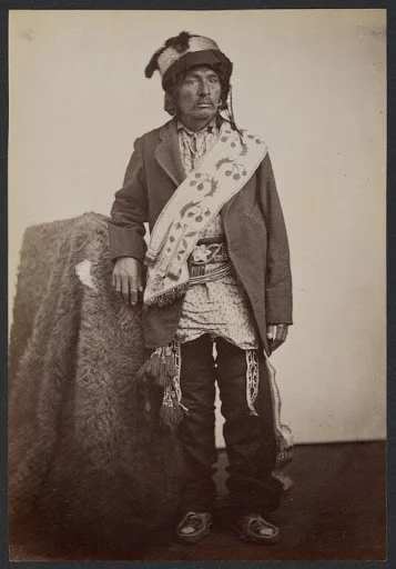 George Washington Caddo, identified as Principal Chief, standing beside a buffalo-robe-draped prop in William Stinson Soule’s photograph, 1869–1874
