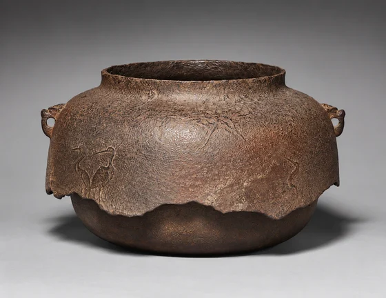 Iron kettle with cranes and broken skirt.