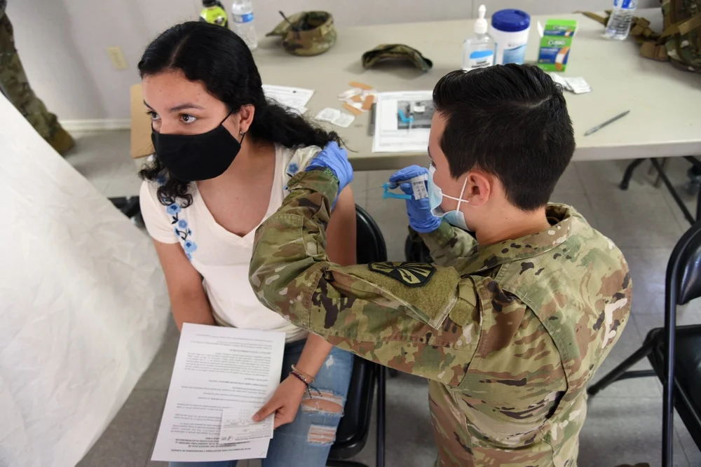 A Tohono O’odham Nation member receiving a vaccination from an Arizona National Guard medic in Why, Arizona, on May 11, 2021
