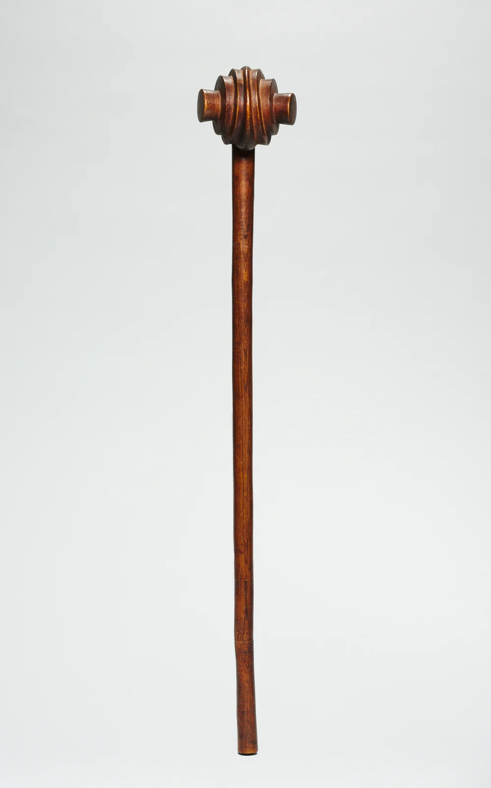 Complete polished brown wooden knobkerrie with a long slender shaft and a ribbed rounded head, catalogued as made by a Swazi-style maker.