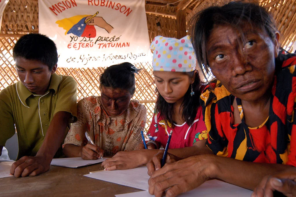 Wayuu participants writing during a Mision Robinson literacy class in Casusai, Zulia, Venezuela, photographed by Franklin Reyes in 2004