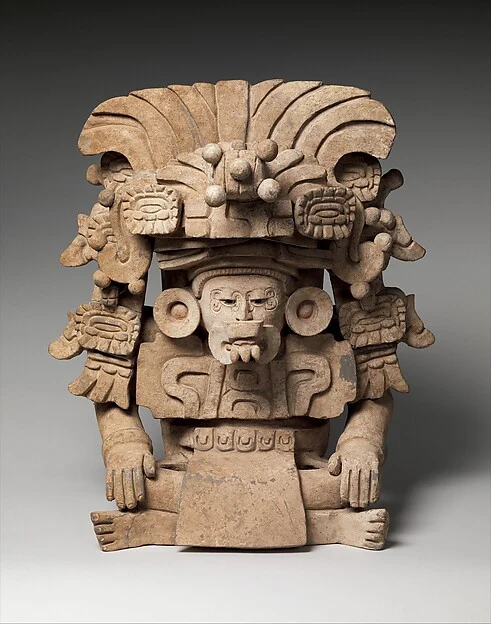 Zapotec Be’ena’a ceramic effigy urn with seated masked figure and elaborate headdress, 350–600 CE, Met 2014.632.2